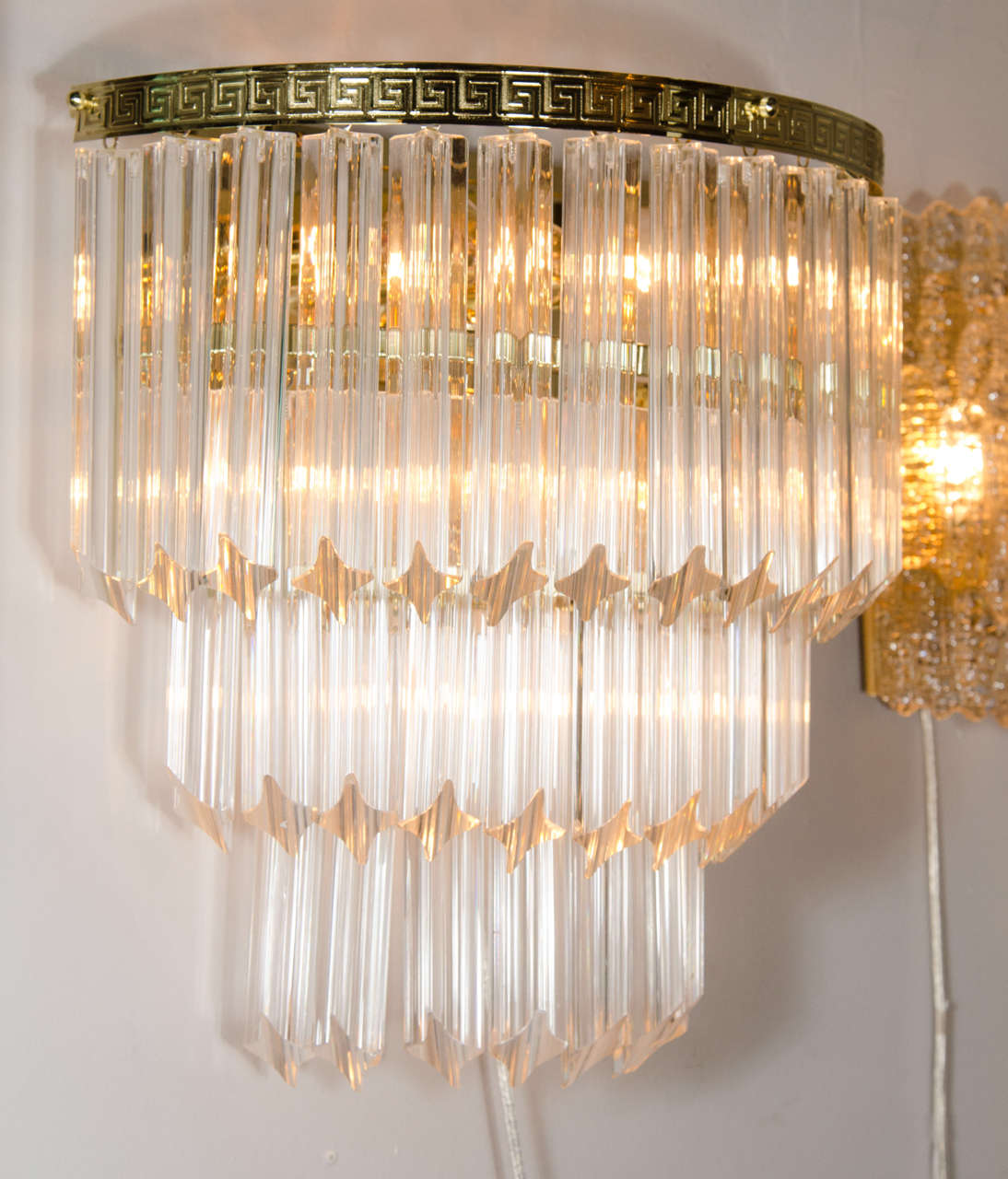 Pair of Mid-Century modernist three-tiered Triedre Camer cut-crystal sconces. This pair of sconces is comprised of three tiers of individually hung Camer Triedre cut-crystal rods, descending from top to bottom, in a staggered formation. The Triedre