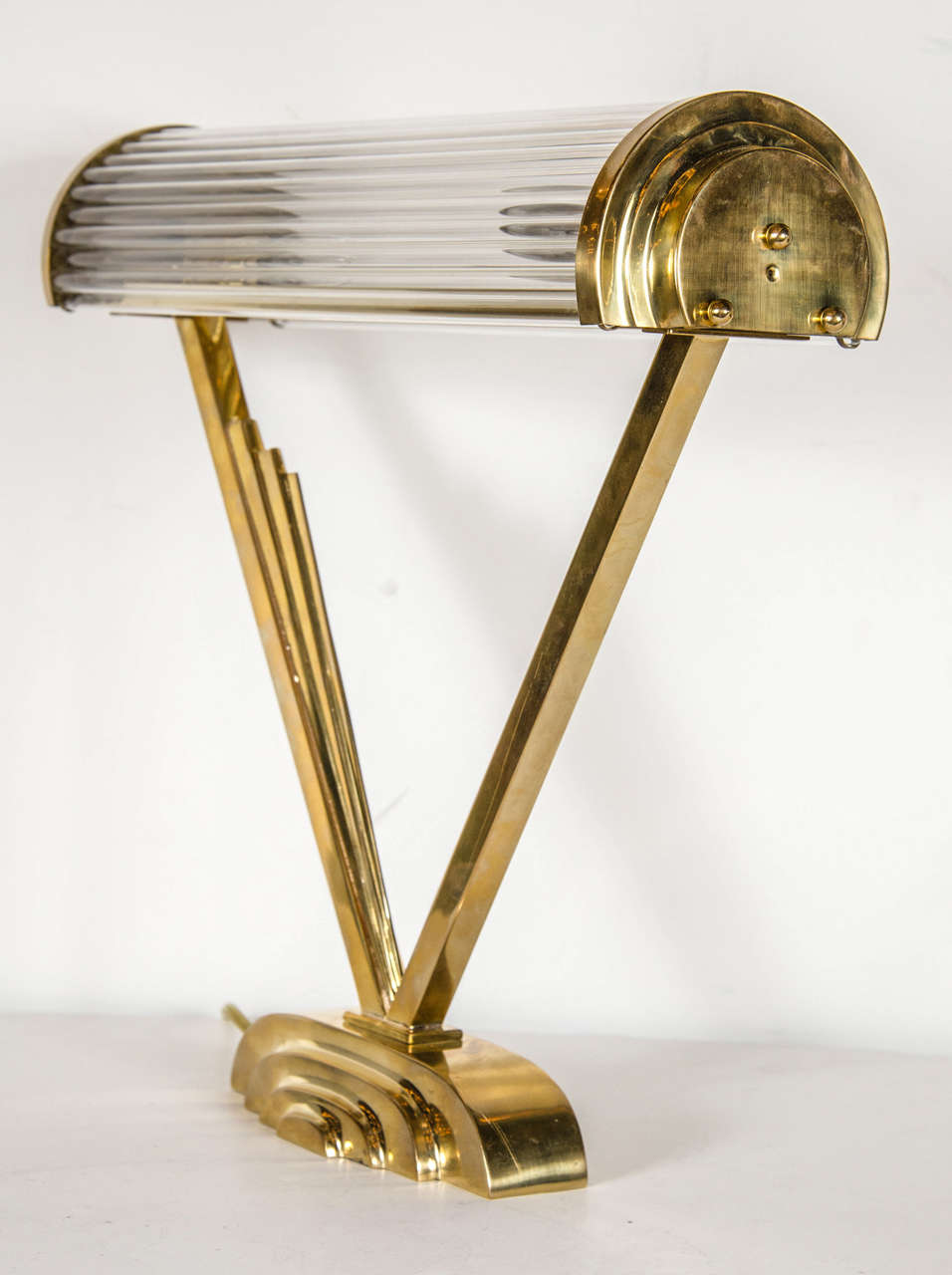 This outstanding Art Deco machine age desk lamp in the manner of Josef Hoffman features a suspended demilune glass rod shade with two candelabrum bulb fittings. The base has streamlined skyscraper style detailing and is newly rewired.