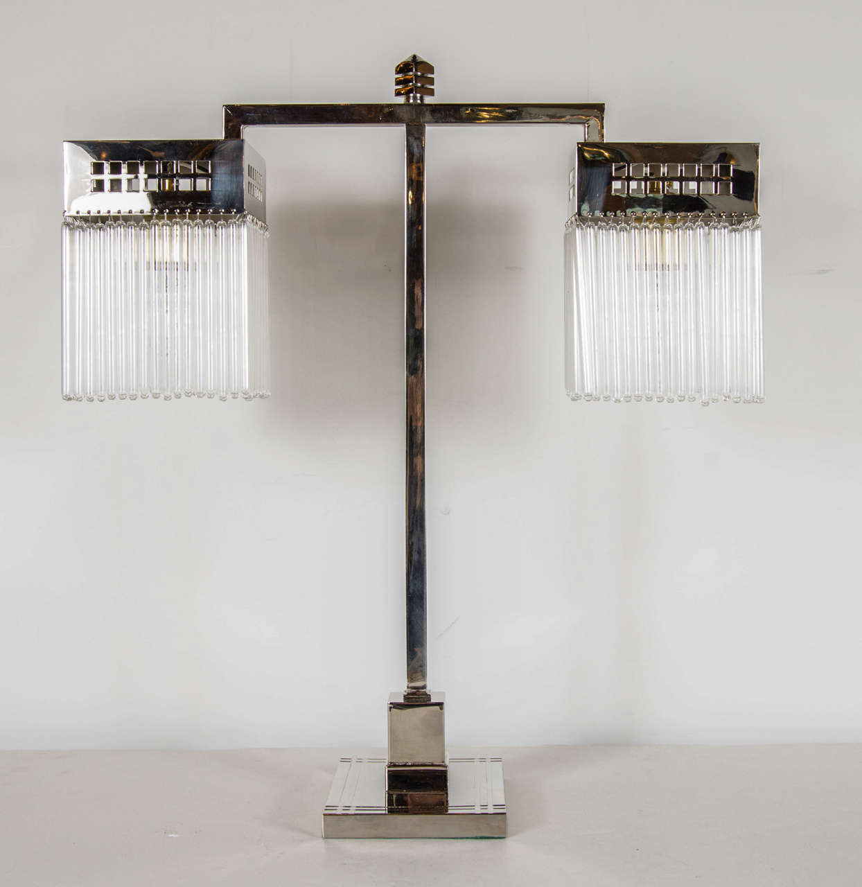 Art Deco Machine Age skyscraper style nickeled bronze table lamp in the manner of Joseph Hoffman. This table or desk lamp features an overall streamlined look with its geometric overall design. It has a squared off base with a two tiered adornment