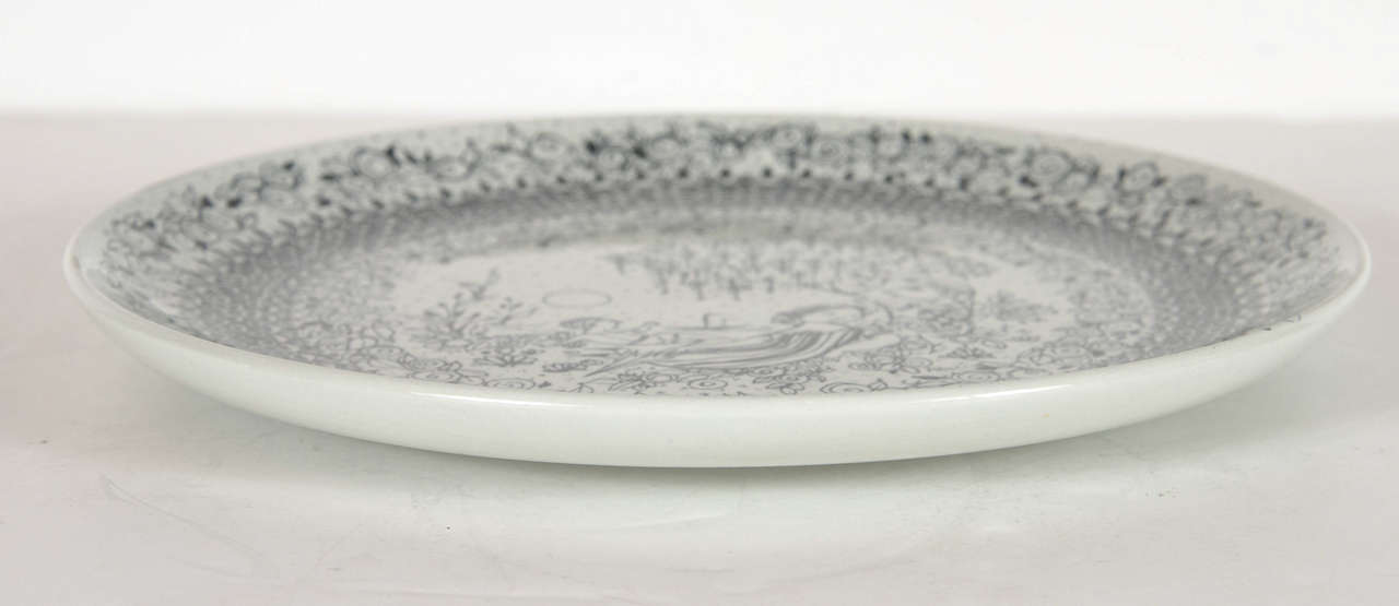 This hand painted plate by the noted artist Bjorn Windblad depicts a father, mother, and child surrounded by stylized flora and fauna with a seascape all representing the best of summer. This is great as a decorative object or can be hung on the