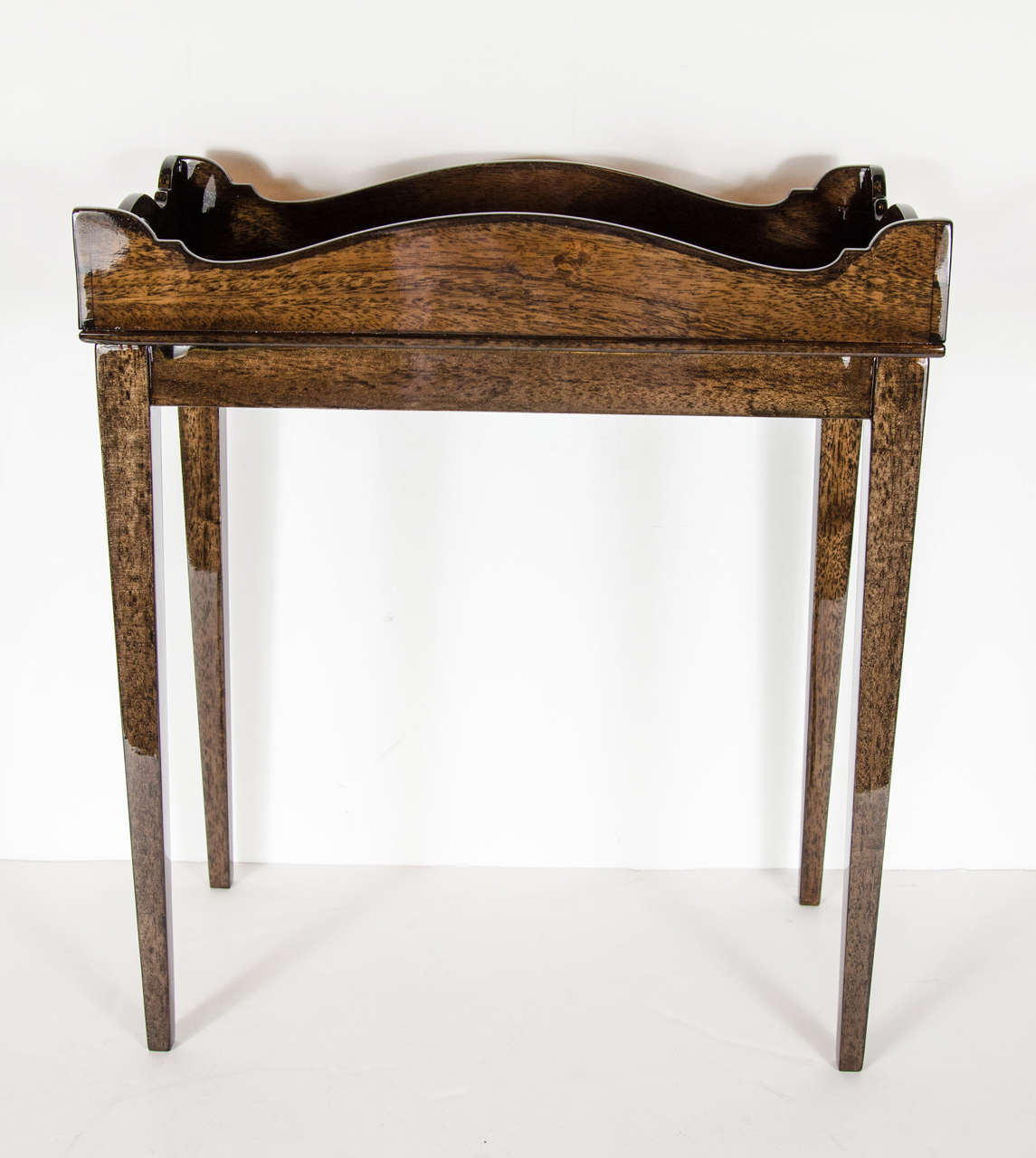 This elegant table features a tapered leg design with a top design of a tray design. It is made of exotic book-matched exotic mahogany. This table has been mint restored.