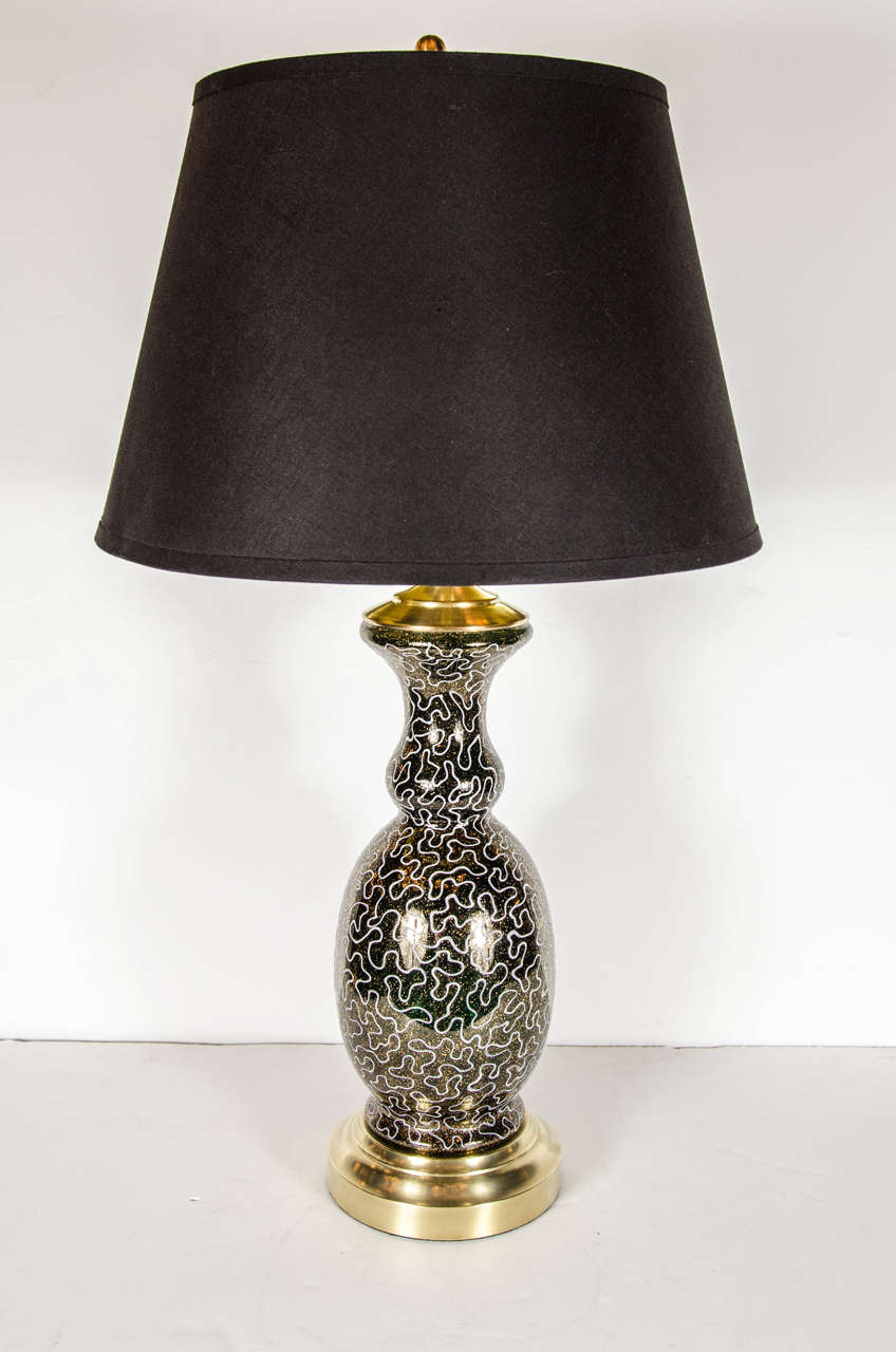This stunning lamp features balustrade form body in black glass that is linear decorated with a gold organic design. It has brass fittings and has been newly rewired with a custom black shade.