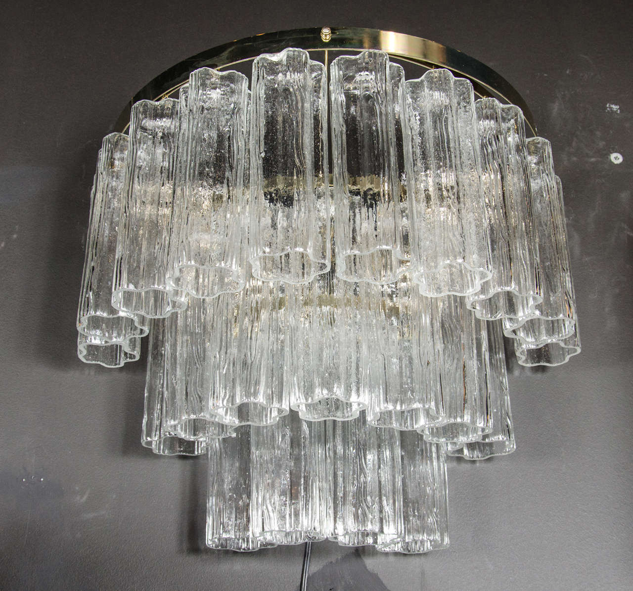 Pair of Mid-Century modernist three-tier tronchi sconces. These sconces feature three tiers of handblown Murano glass tronchi shades that are individually hung from their half-circular brass frames. The top-tier supports ten tronchi glass shades as