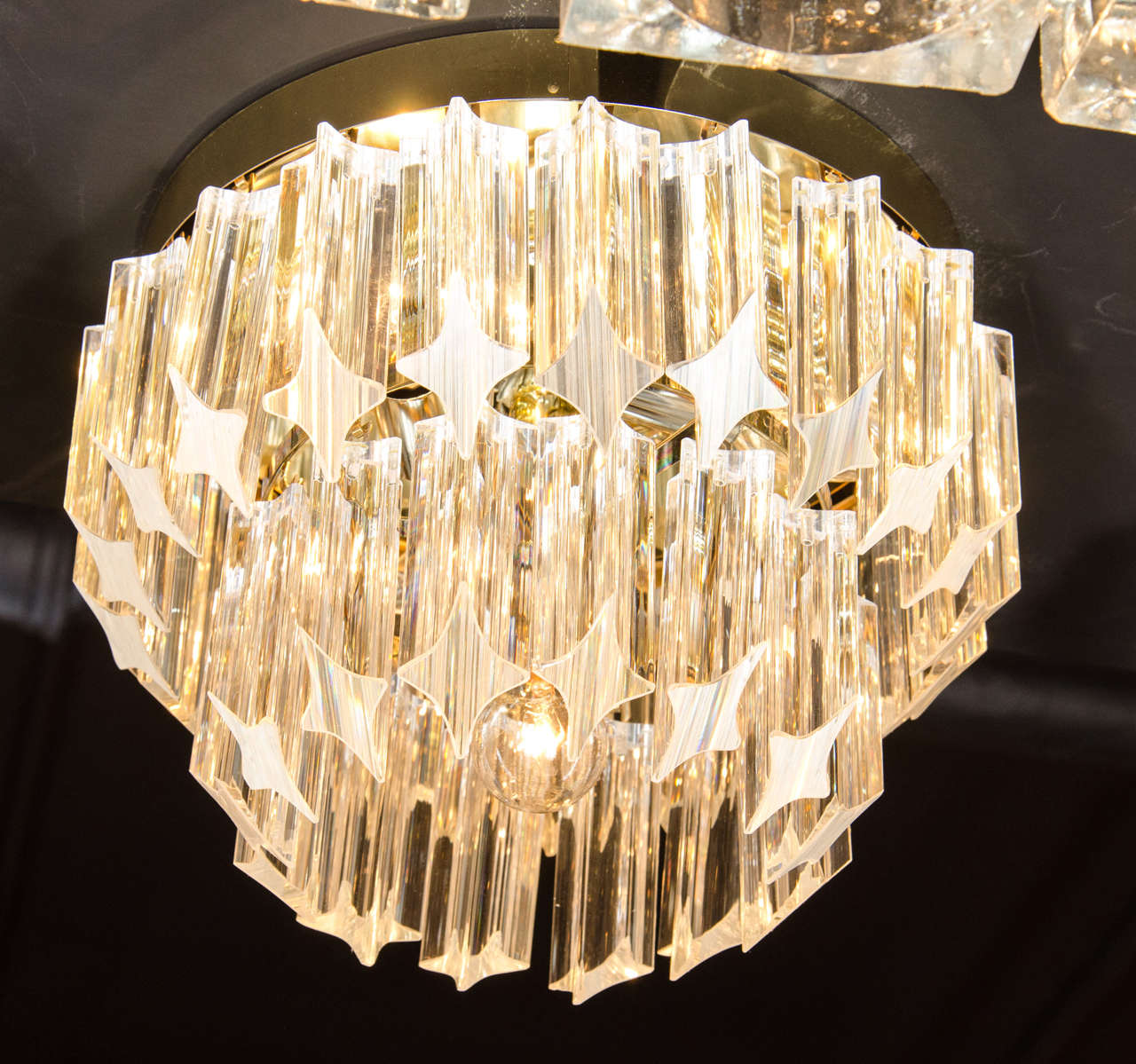 Mid-Century Modernist cut crystal flush mount chandelier by Camer. This flush mount chandelier features two tiers of cut crystal Triedre rods that have been cut at an angle and hung in a descending fashion for added dimension and style. Each tier of