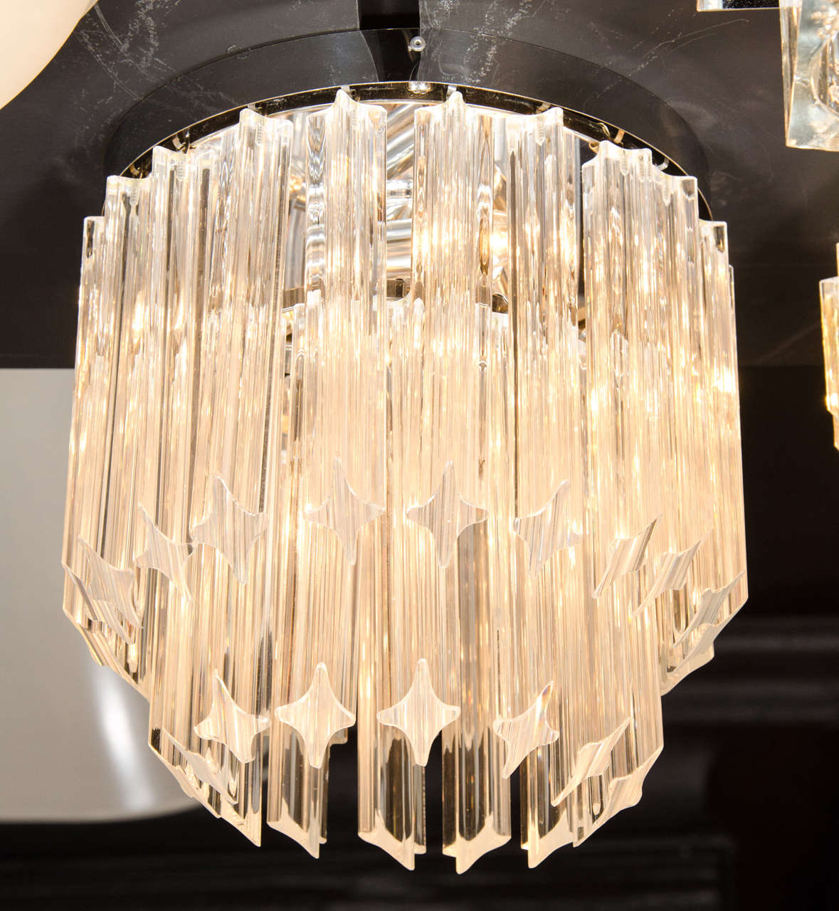 Mid-Century Modernist cut crystal flush mount chandelier by Camer. This flush mount chandelier features two tiers of cut crystal Triedre rods that have been cut at an angle and hung in a descending fashion for added dimension and style. Each tier of