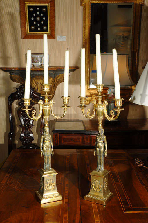 a pair of bronze First Empire candelabra in the form of caryatids supporting an urn, each candelabrum holding three candles