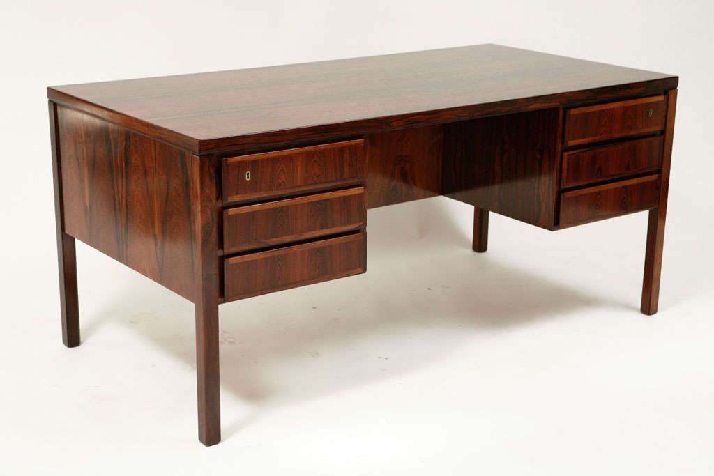 Gorgeous solid rosewood desk designed by Gunni Omann with breathtaking grain to the rosewood.  The desk is designed with storage in mind with floating drawers, open bookshelves and a drop down door revealing more shelving. <br />
An absolutely
