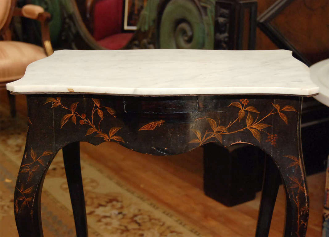 A very delicate lacquered side table of particularly delicate proportions with a white marble top.
