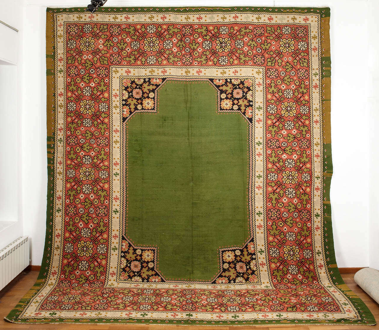 A rare and unusual Bessarabian flat-weave, characterized by a grass green open field with stylized floral spandrels and a wide border. Bessarablian kilims of such large format are very difficult to find as they probably were originally commissioned