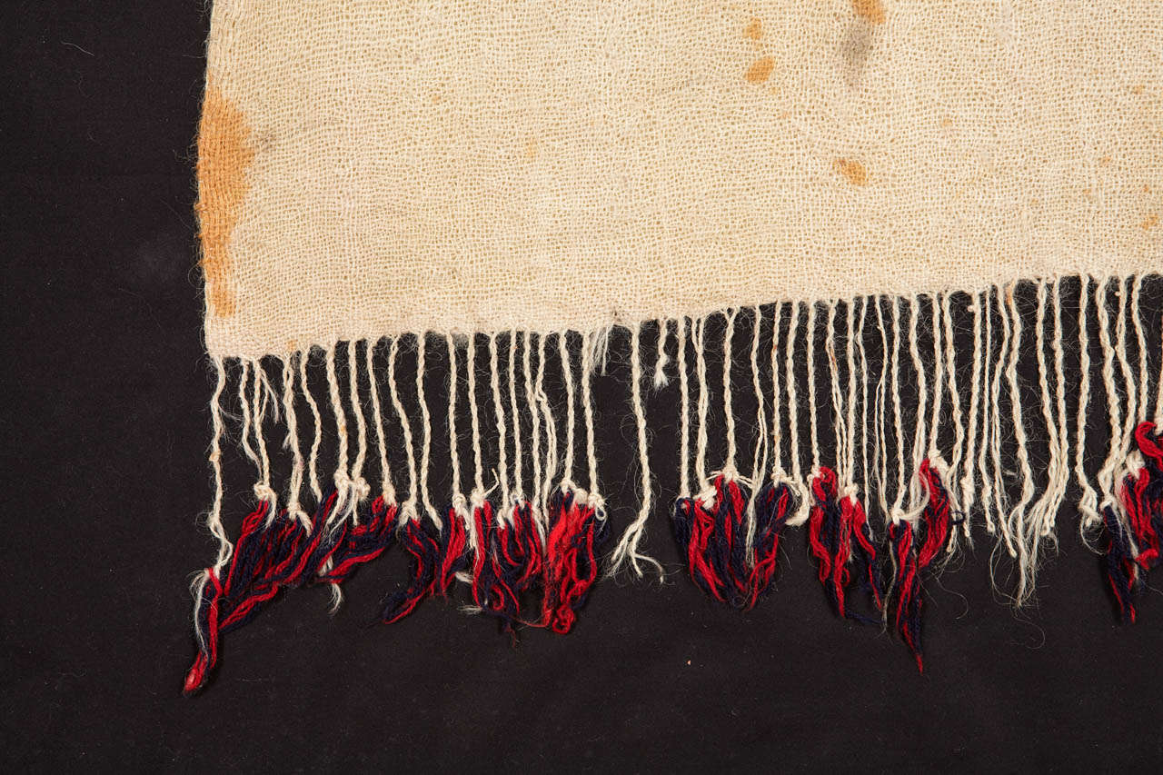 A very finely woven wool veil used as a head cover in the wedding ceremony among the Ida Ou Zeddout Berber people of the Moroccan Anti Atlas region. The red tonality is obtained with the resist-technique using henna pigments. Conserved on a black