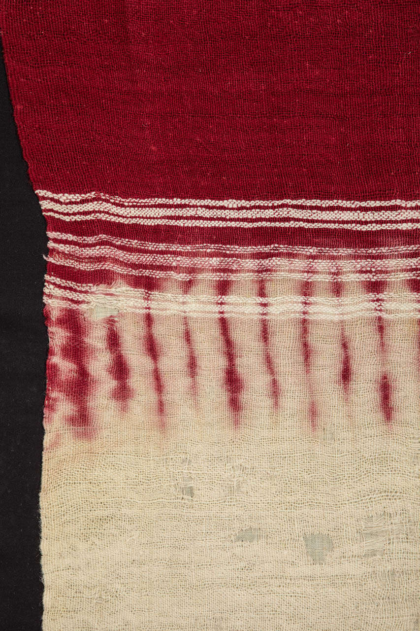 A very finely woven wool veil used as a head cover in the wedding ceremony among the Berber people of the Moroccan Anti-Atlas region. The pattern is obtained with the resist-technique using henna pigments. Mounted with a black backing on a wooden