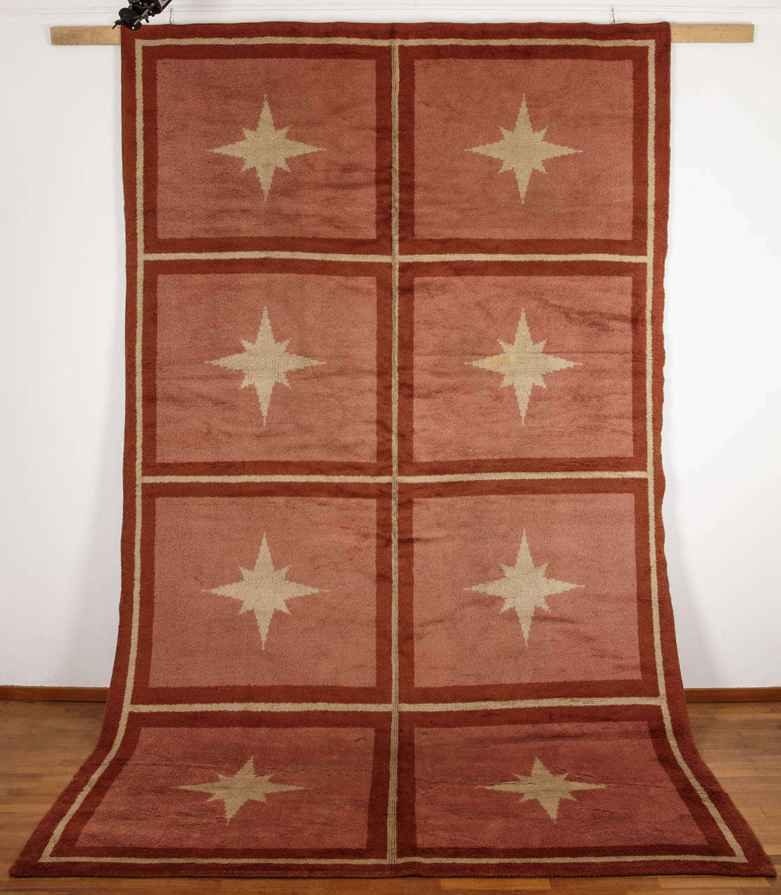 The early carpets of the Art Deco period had the prerogative of proposing a new set of patterns based on re-interpretation of classical western decorative motifs. 
In this example we see a compartment design typical of French and English needlepoint