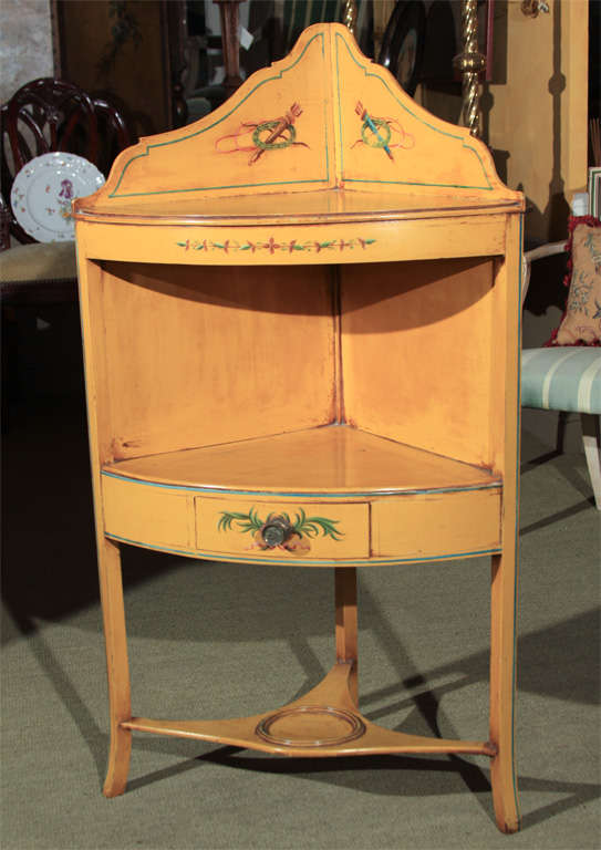 A well painted and decorated late 29th century English corner stand(originally as a washstand) with a lower shelf and small drawer