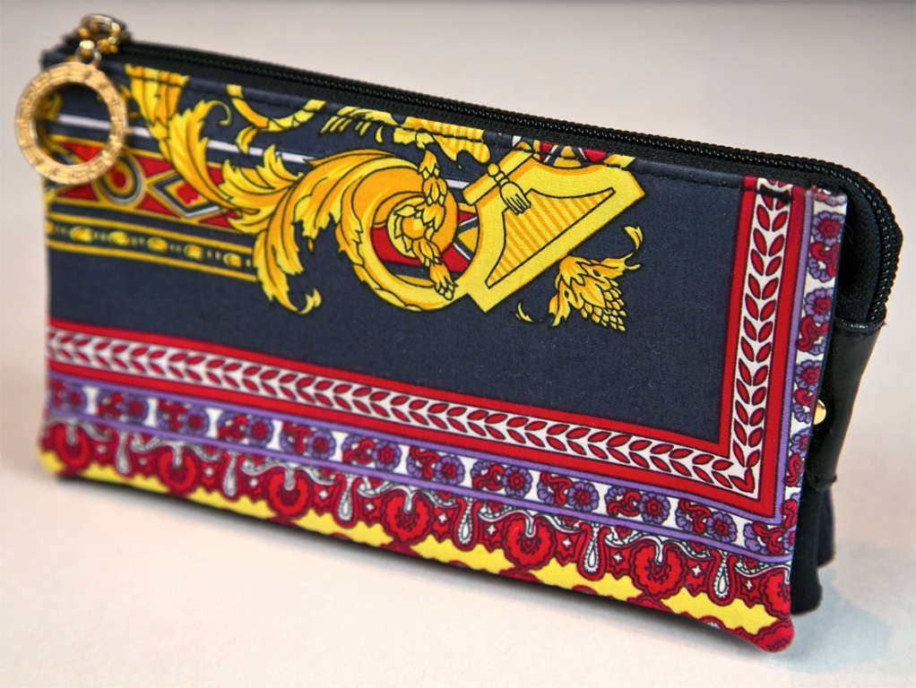 funkyfinders shares this lavish print versace purse with a crisp textile surround. its greek key motif zipper pull is notable. it features 5 (!) compartments: 1 of which is zippered. the label is intact. ideal for travel as per passports and jewels;