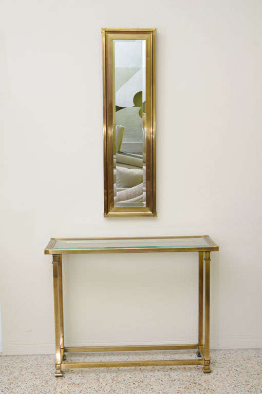 SOLD FEB 2013 Elegance for the area that needs a petite size treatment in this masterful slim line heavy brass console with a molded top and beveled glass insert.  Complimented by a slim line rectangular matching mirror with a beveled mirror glass. 