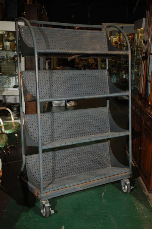 Offering a very cool rolling industrial shelf unit. This piece was originally made for Barnes and Noble to cart books around--thus the slanted shelves. It's roomy, clean, has four locking wheels, and looks good from all angles. This would make a