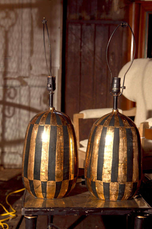 Spectacular gilt and black egg shape ceramic lamps from Italy. Height to top of harp is 27