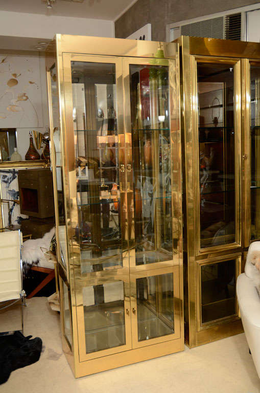 Decorative, midcentury, brass vitrine cabinet by Mastercraft, circa 1960. Very well built. Two doors with built in lighting. Glass shelves inside the cabinet.