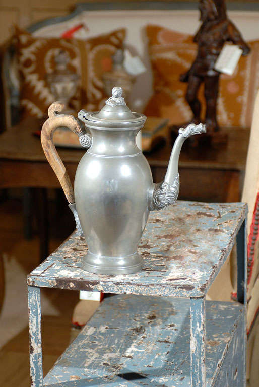 A number of different motifs were used to decorate this wonderfully old pewter coffee pot.  There is a pomegranate on the lid, a gargoyle type face at the bottom of the handle, a dragon's head at the end of the spout and acanthus leaves at the base