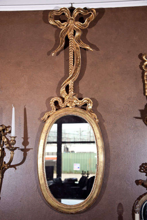 A pair of Venetian water gilt, ribbon and tassel intertwined rope mirrors. Mirror plate replaced.
