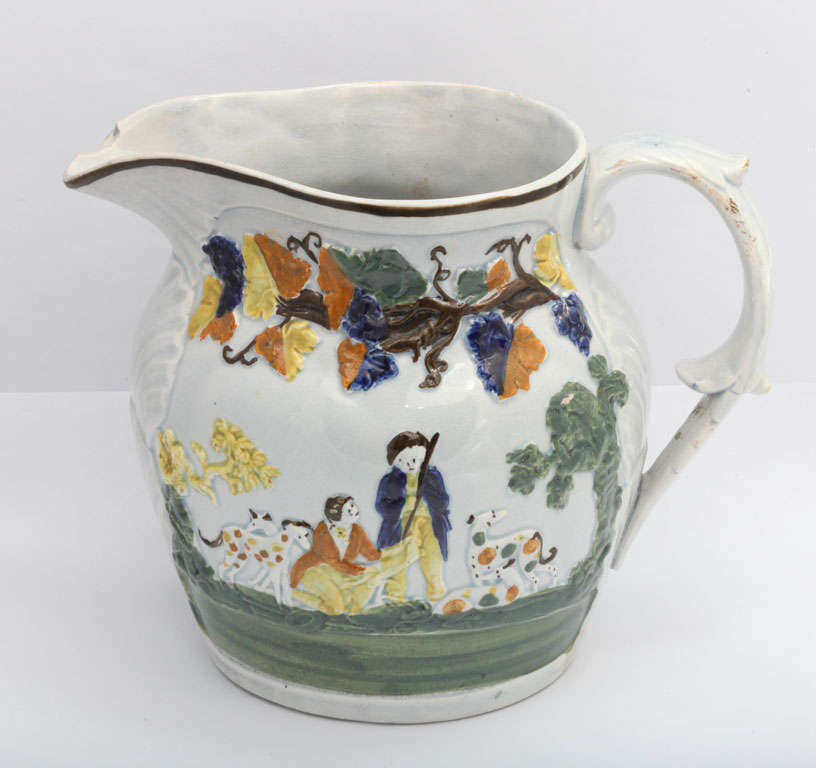 A fine Engish pearlware pottery pitcher molded with a hunting scene and hounds and decorated in underglaze Pratt colors