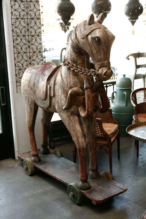 Life size hand-carved wood Anglo-Indian temple horses with  poly-chrome decorated sitting a top of a wheeled board.
almost 6 feet high(67