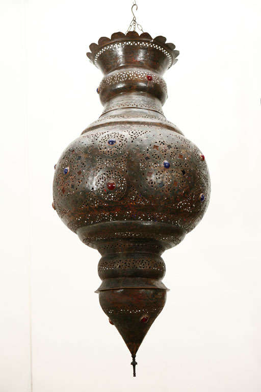 Antique Moroccan bronze Moorish light fixture.
This large Moorish chandelier is delicately hand-carved and hand-hammered with Moorish floral designs, incrusted with small jeweled colored glass.
The light fixture is : 72