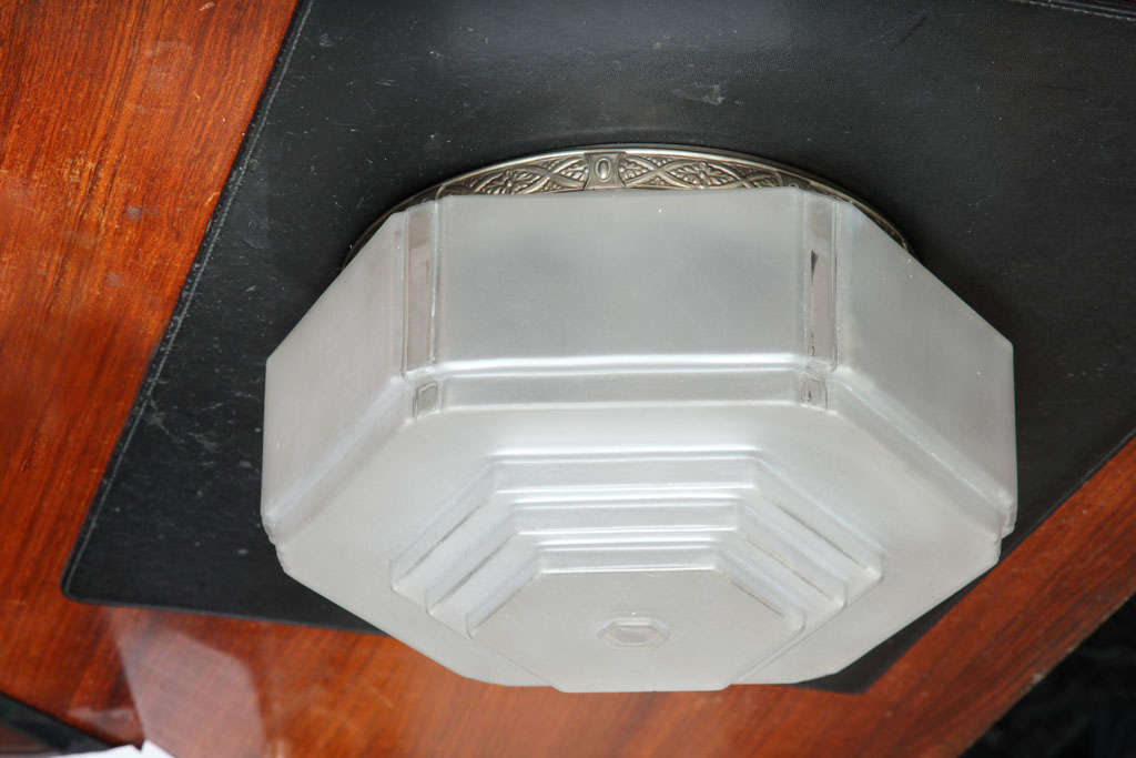 French Art Deco ceiling fixture of stepped hexagonal shape, with frosted glass shade in a nickeled brass mount.