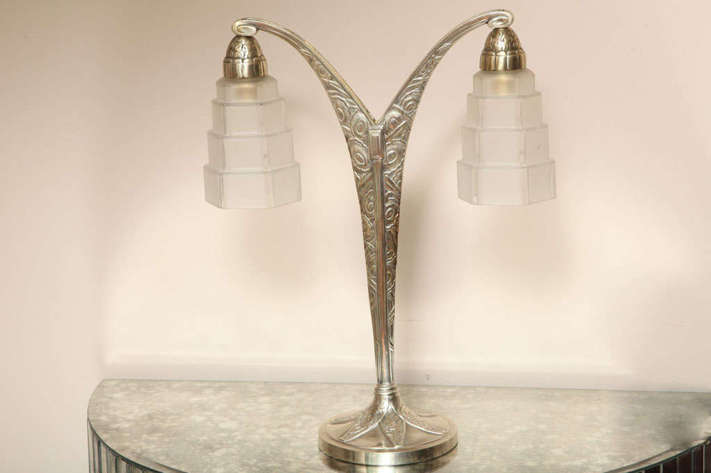 FRENCH ART DECO TWO-ARMED TABLE LAMP<br />
nickeled bronze with two  stepped frosted glass shades<br />
17¾in. high, 14 1/2 in.  wide