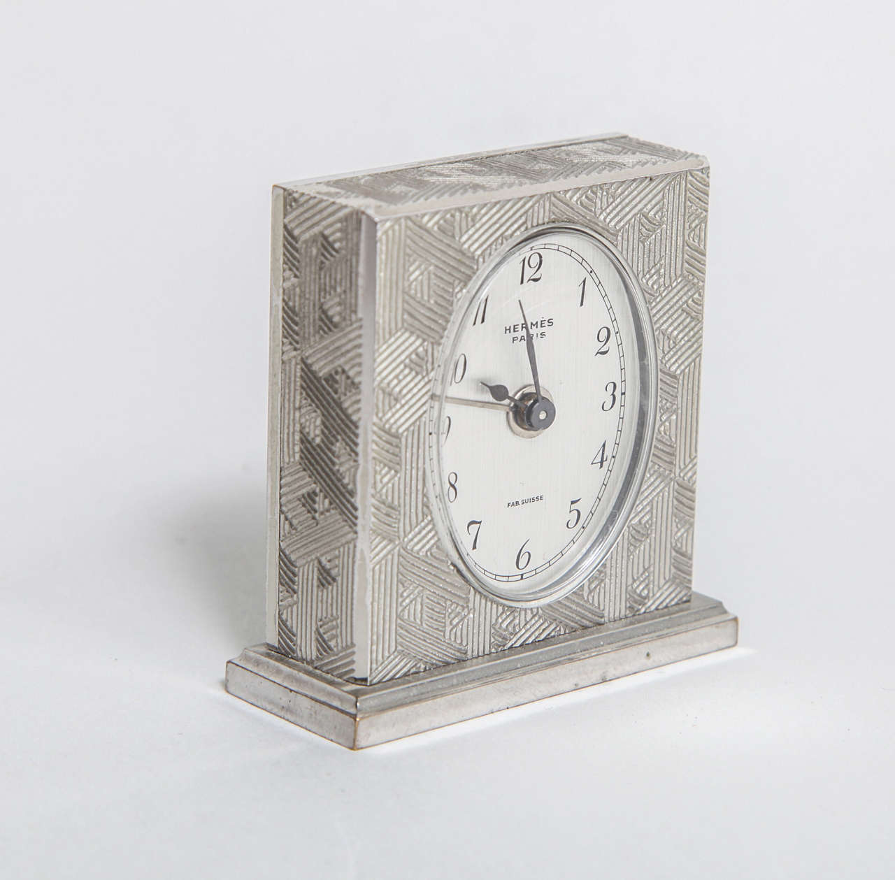 A fabulous Art Deco Hermes travel alarm clock with a geometric pattern on plated bronze body. This clock is in its original velvet lined gate front fitted suede box which has the Hermes logo and Parisian address. The movement is made in Switzerland
