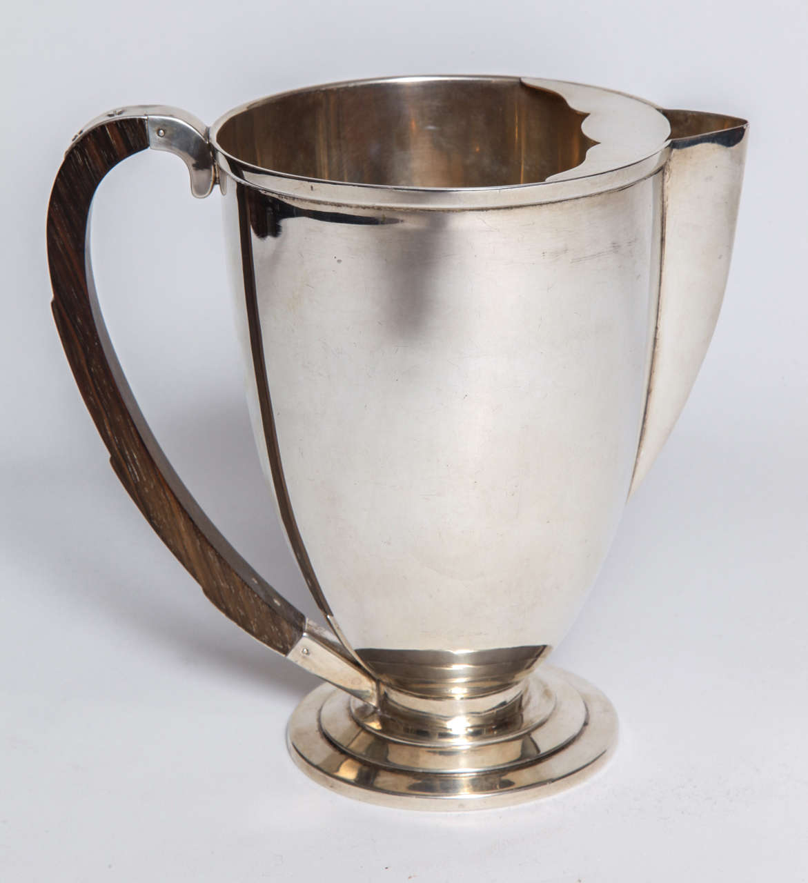 An American Art Deco water pitcher, 1928 by International Silver Company sterling silver with a stylized ebony handle. The pitcher has a round stepped base with a stylized ebony handle. Pure American Art Deco.
A Coffee Pot of identical design is