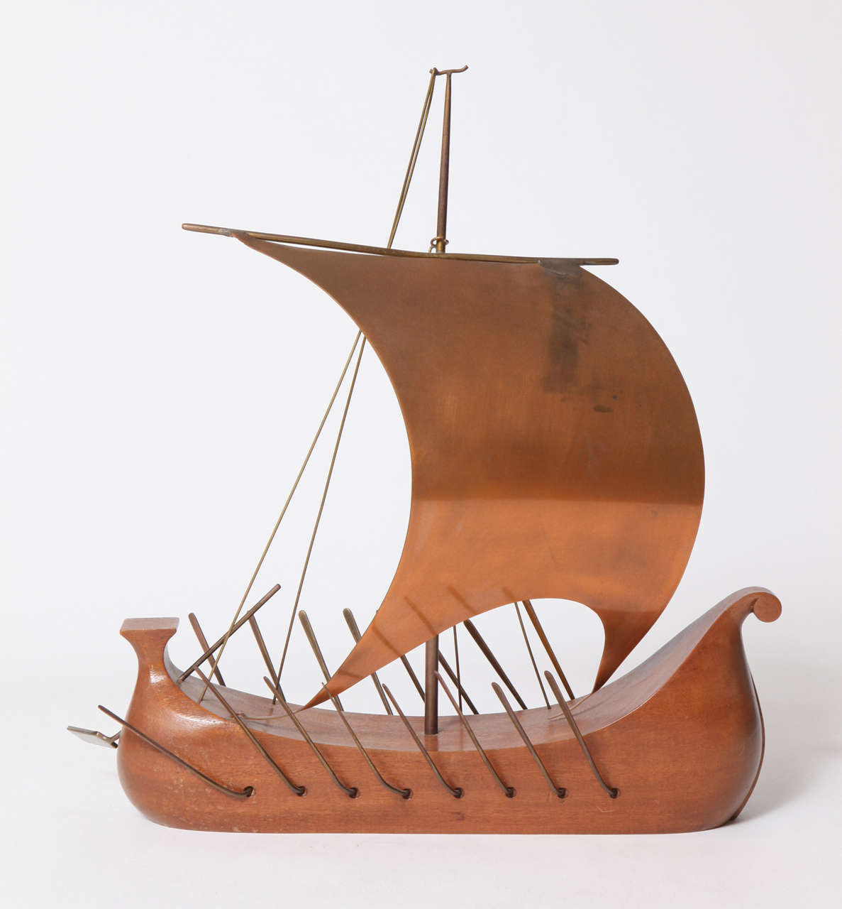 A Hagenauer Werkstatte Hand Carved Wood, Handmade Brass and Copper Oars and Sail. Marked on the underside of the Hull, WHW, Handmade,
Made in Austria, Hagenauer Wien.