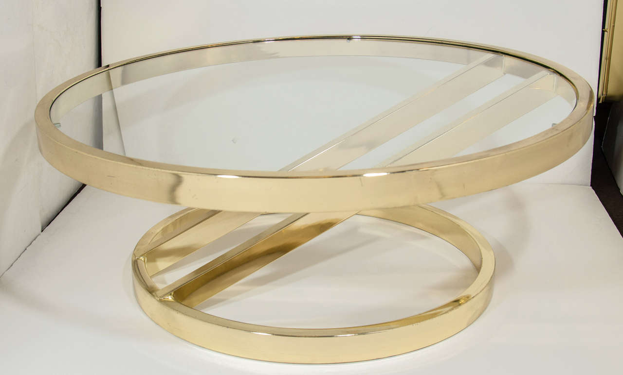 Outstanding mid-century modernist cocktail table with asymmetrical base and cantilevered frame design. The table is comprised of polished brass metal with a circular form, and is fitted with a glass top inset. Price has been reduced from $3,675.