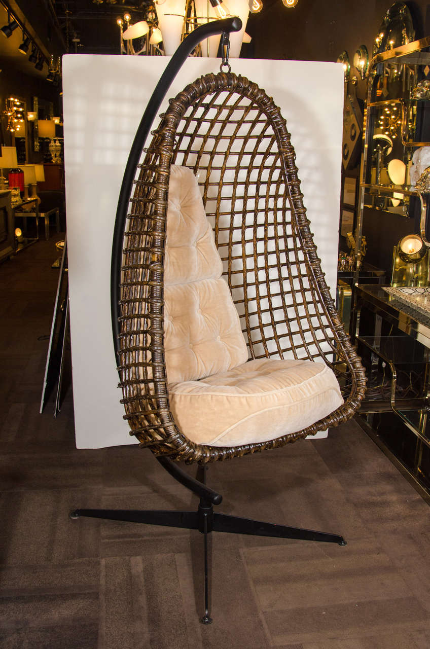 Rare outstanding mid century modern hanging cocoon chair with braided rattan in dark walnut finish. Cushions in camel mohair and base made of black enameled cast steel.