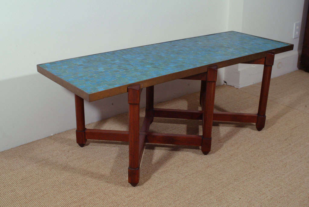 The rectangular brass framed mosaic tiled top, supported on a six legged mahogany base.