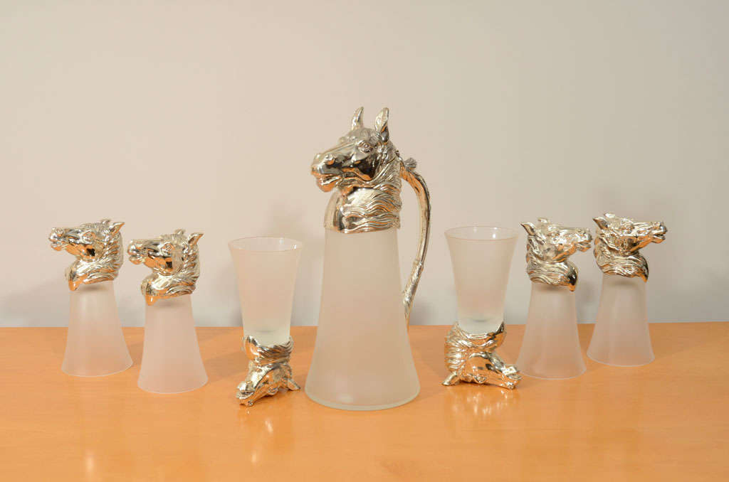 Frosted glass decanter and glasses with nickel plated horsehead details. Measures: Decanter 115 H x 6 D x 4 W.
Glasses 6.5 H x 3.5 D x 2 W.