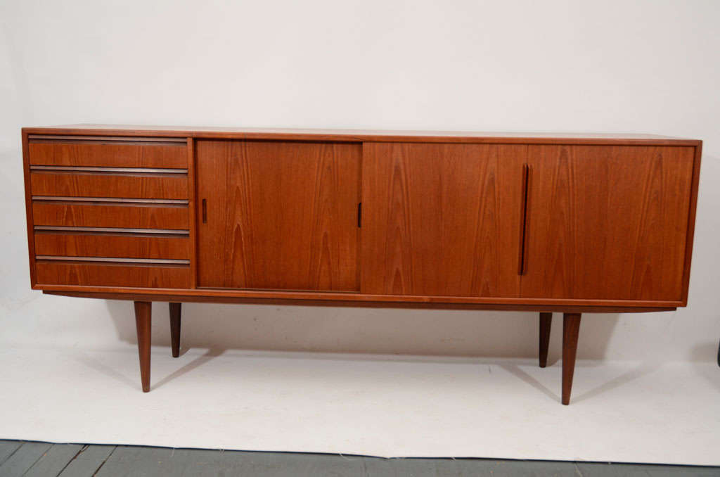 Attractive and sleek Danish teak credenza or media cabinet with drawers and sliding doors. Please contact for location.