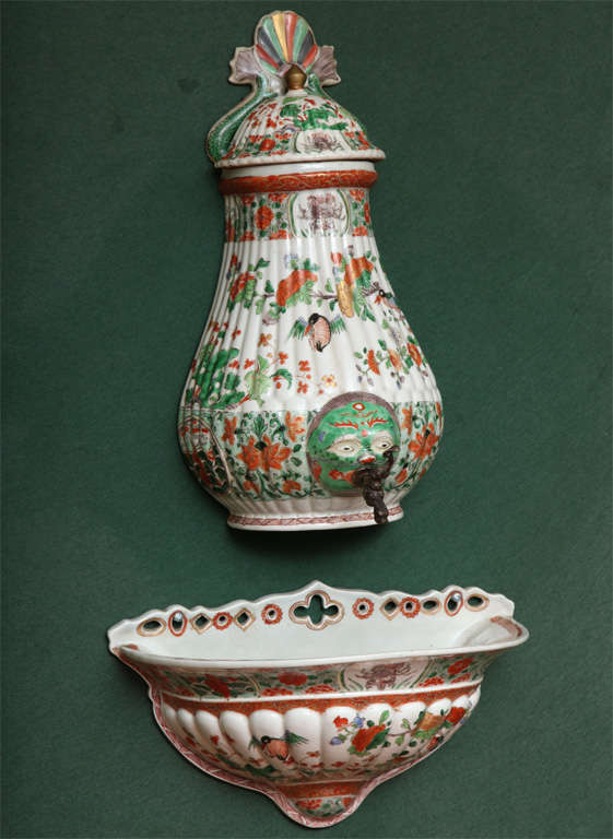 Fine antique Samson famille verte porcelain lavabo and cistern with polychrome fan shaped top centered by dolphin fins above a lobed lid and body centering a green and red articulated face with dolphin spout, and having a conforming basin with
