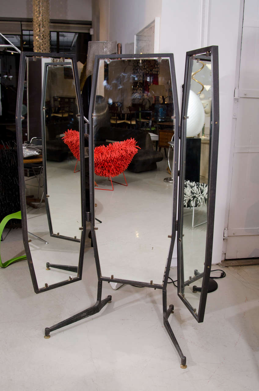 This industrial yet elegant adjustable mirror has a frame of black wrought iron and stands on four sturdy legs with gold accent feet. Totally adjustable to get a look of every angle. This mirror is Italian from the 1950's with the classic black and