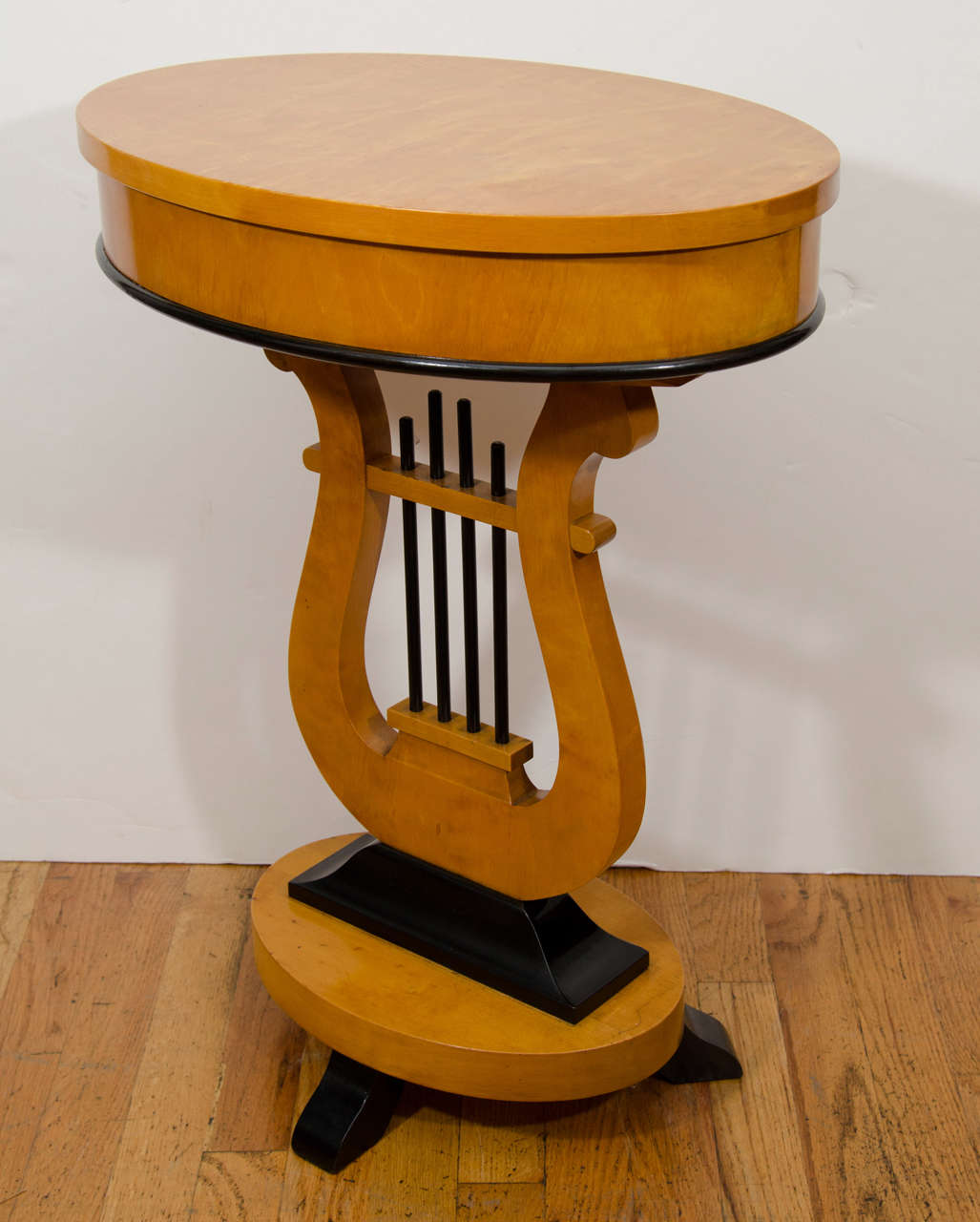 The lid of this lyre shaped birch occasional table lifts to hold spools, knitting needles and assorted sewing notions.  Every  nineteenth century Swedish home featured a cosy spot for domestic endeavors including a sewing table.
