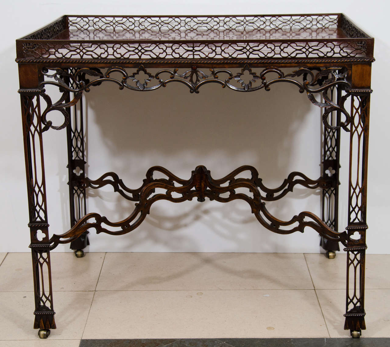 George III Chinese Chippendale mahogany silver table with pierced fretwork gallery, apron, legs and arched shaped stretcher.  Now with casters.