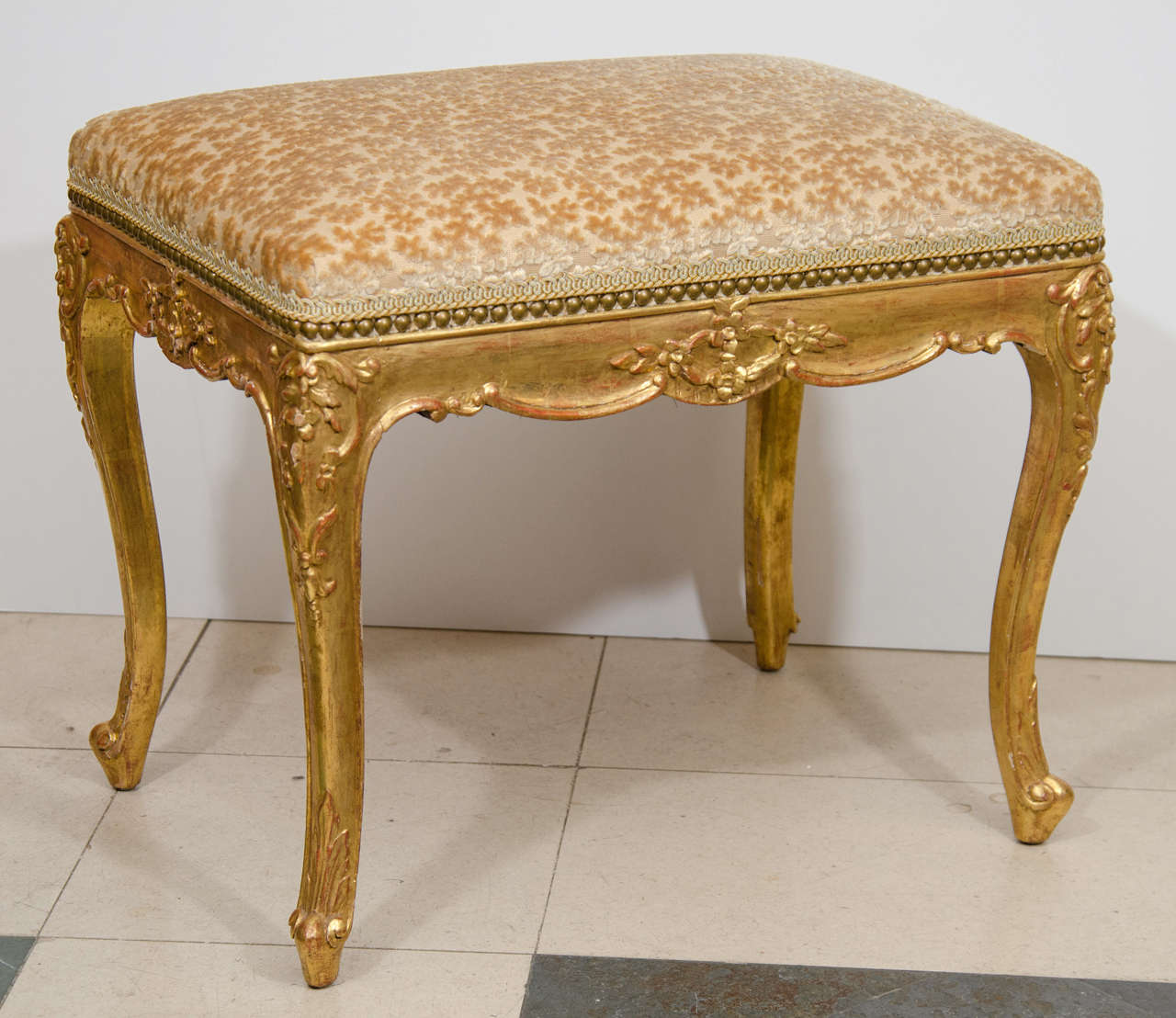A pair of Louis XV carved gilt wood and upholstered stools.