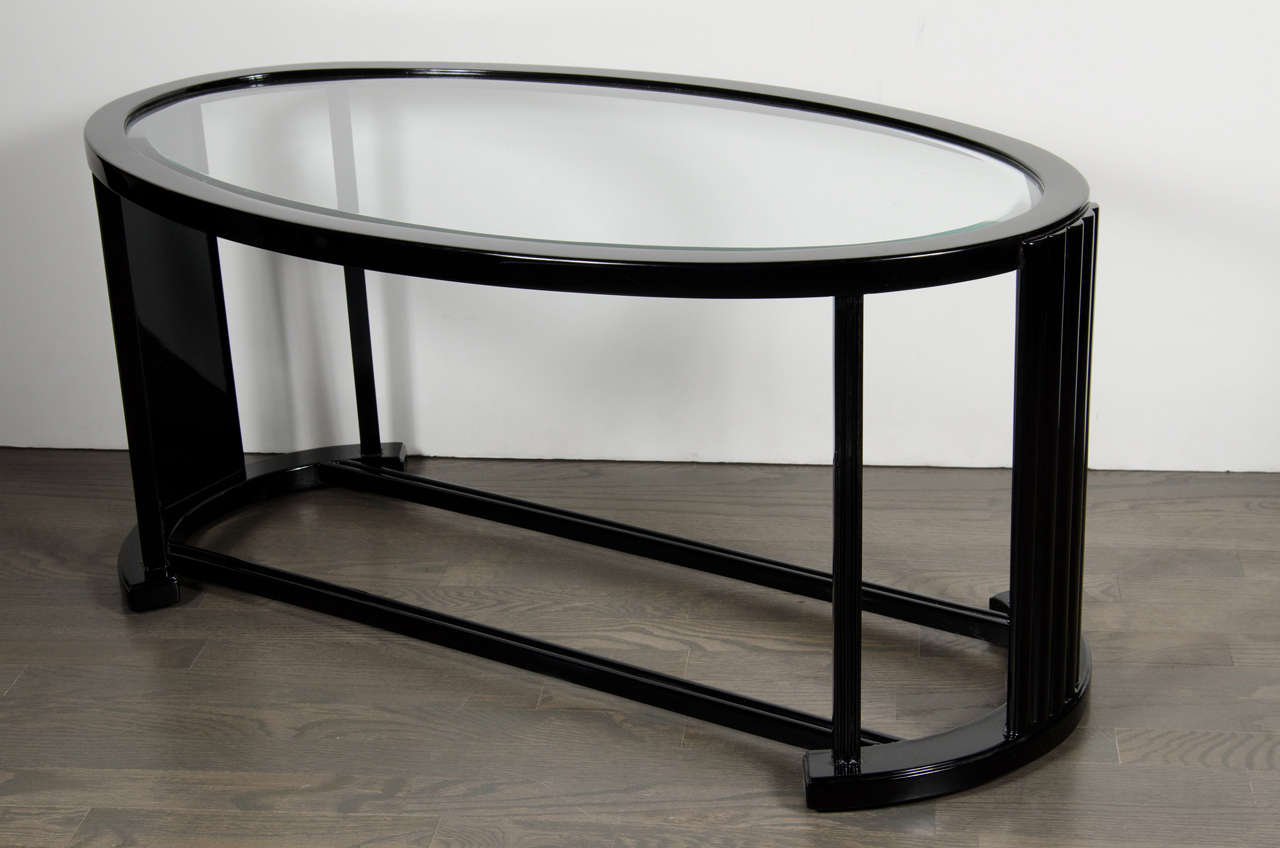 This Art Deco cocktail table features an ovoid design with fluted supports of varied width's and supports which emulate the shape  of the table top. The table has symmetry, style and an aesthetically light presence. Completely restored to mint