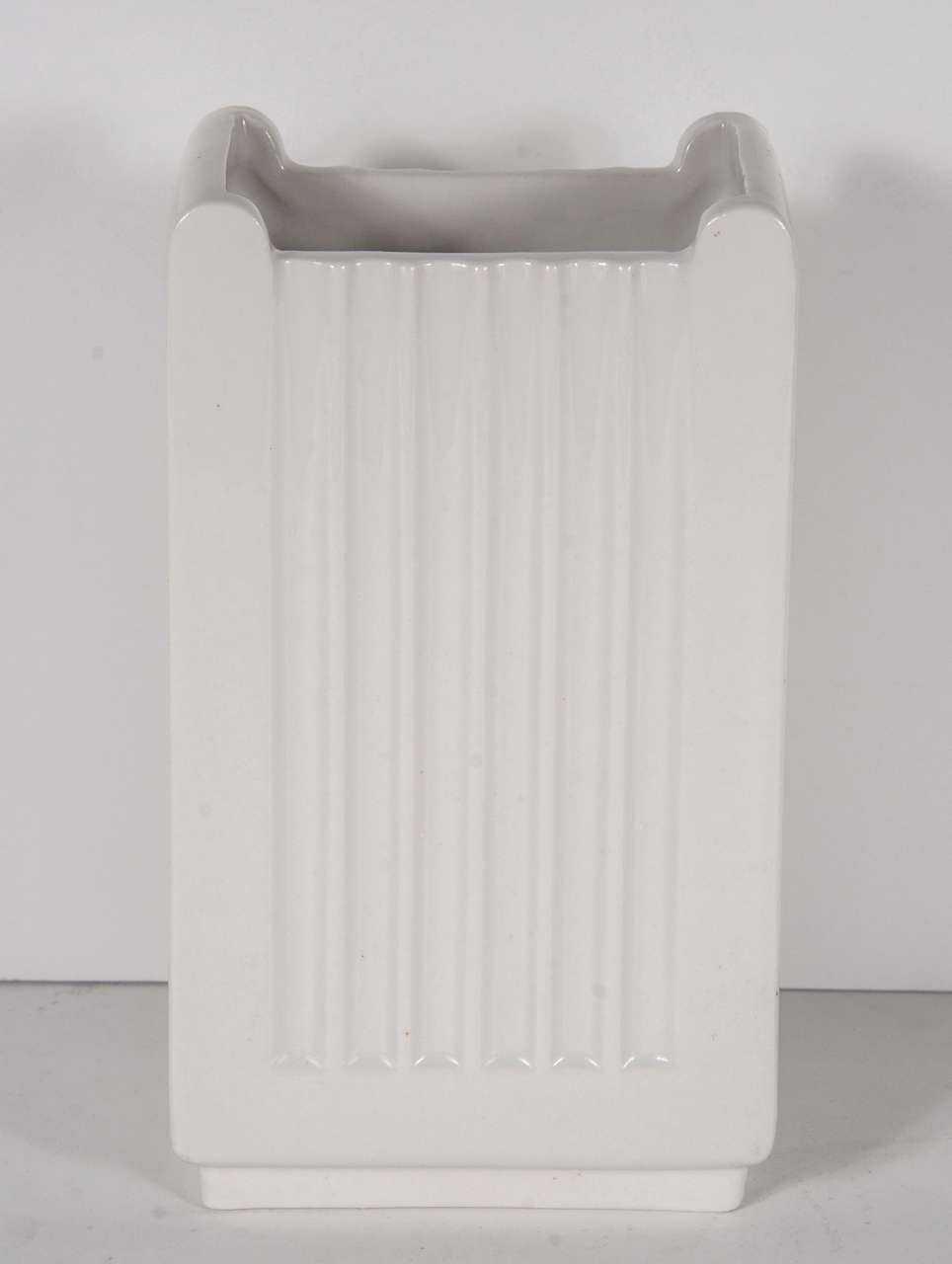 This highly stylized vase features a fluted design with skyscraper detailing.It is a gorgeous creme ceramic and bears the Trenton Potteries mark on the bottom.
