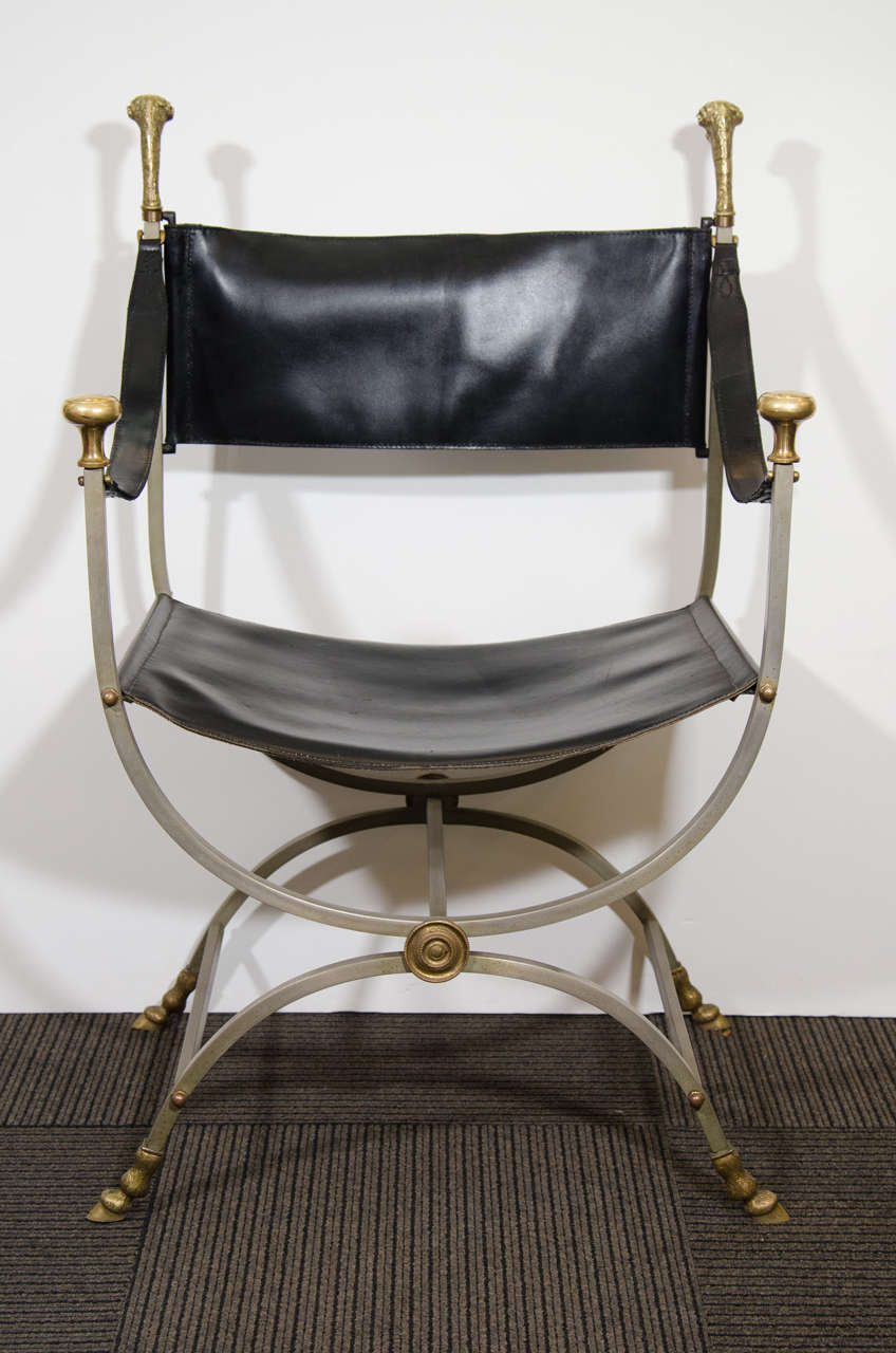 Exquisite Pair of steel and black leather chairs marked Italy with Sculpted brass Ram Head Finials Designed and Made by Maison Jansen. The  Arching Steel Square Tubular Legs are capped with Sculpted Brass Ram Hooves adding a Great and Ornate Flair.