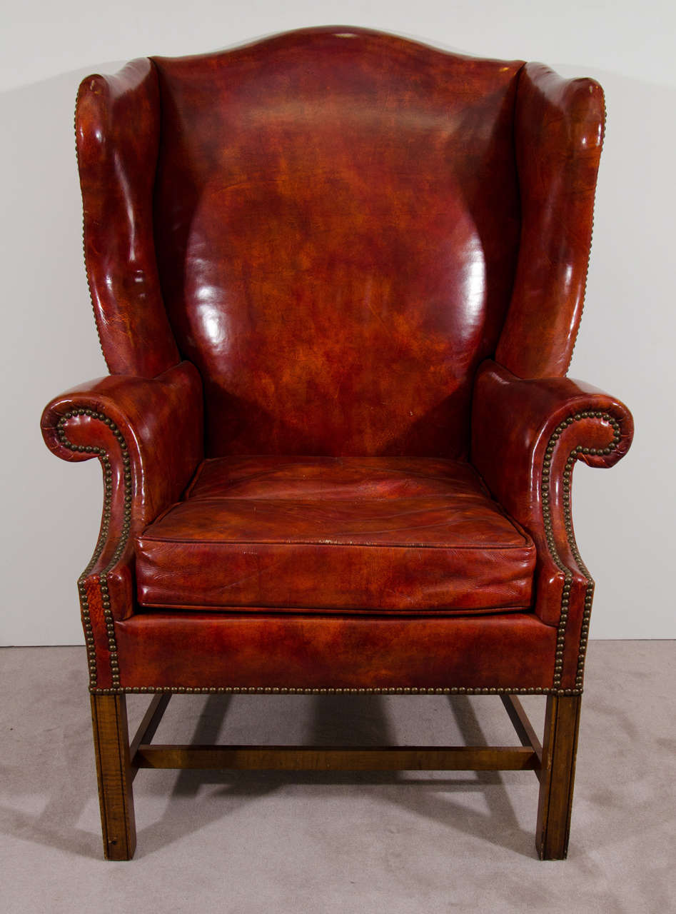 A vintage pair of burgundy leather wing chairs with brass nailhead detail by Baker.

Good vintage condition with age appropriate wear. Some scuffs to the leather and wood.