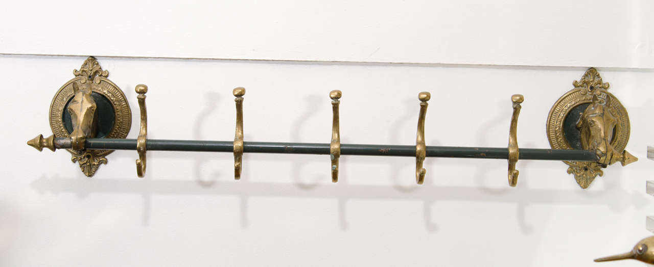 A vintage coat rack in solid brass with five hooks with a horse head adorning each side. Retains its original 'hunter green' lacquer paint.

Good vintage condition with age appropriate patina. 

Item available here online, or at my showroom