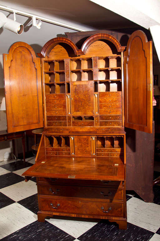 This handcrafted, walnut secretary or slant front bureau bookcase, in the manner of Queen Anne style, is made for us by English craftsmen, using time-honored techniques. Myriad drawers, pigeon holes and cupboards fill the well-appointed interior, a