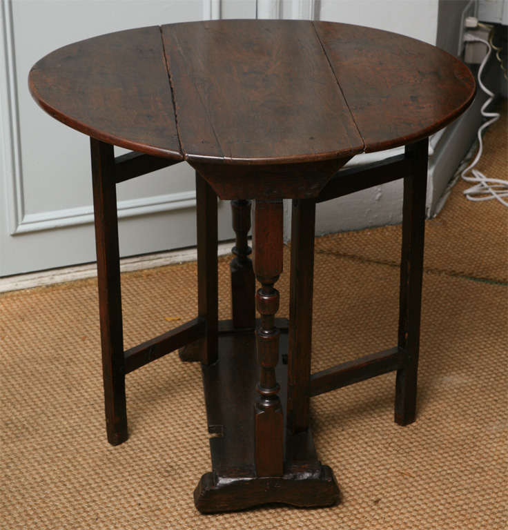 Lovely 17th century English oak gatleg table, the oval top with molded edge, boldly turned legs standing on shoe feet, the base with molded board and having framed square swing legs, the whole with great color.
