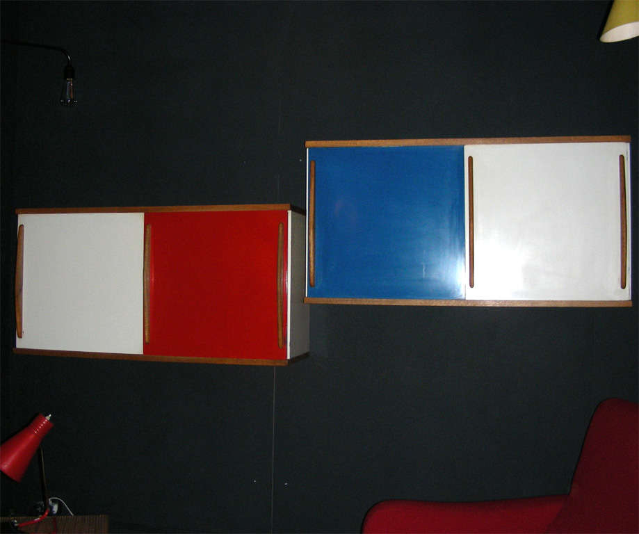 Two 1950s hanging cabinets by Willy Van Der Meeren in oak and blue, white, red wood. Two sliding doors, one interior shelf.